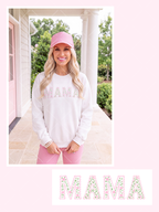 Pink scalloped MAMA lettering filled with tiny pink roses and green leafy vines, shown on a white sweatshirt mockup.