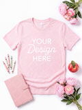 Pink T-shirt flat lay mockup styled on white with pink flowers, a planner, pastel crayons, and a red apple.
